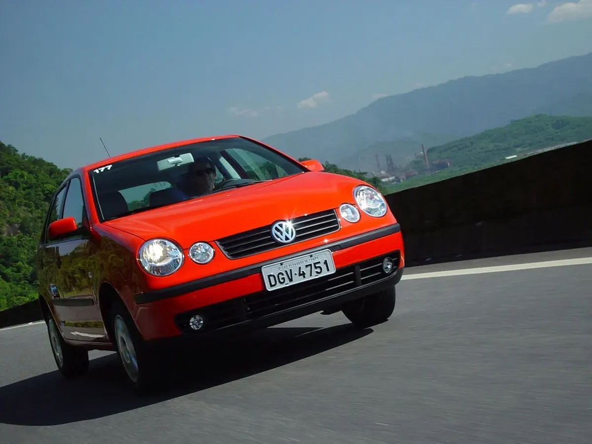 Volkswagen Polo circula por estrada asfaltada em área urbana brasileira